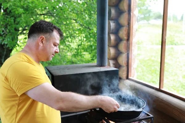 男は釜で沸騰キノコをミックス カレリア — ストック写真