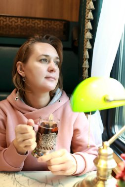 Tren kompartımanında çay içen kadın portresi