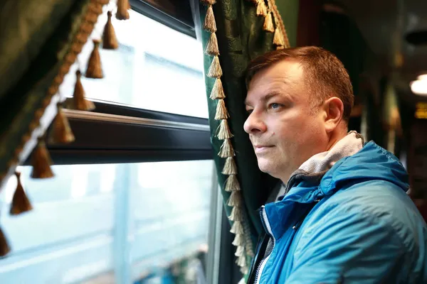 レトロな電車の中で窓の外を見る男の肖像画 — ストック写真