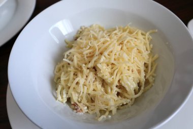 Restoranda beyaz tabakta peynirli makarna