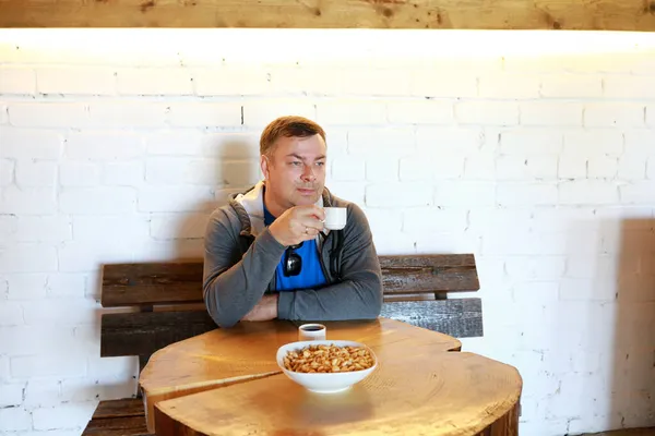 Yuvarlak Tahta Masada Simitlerle Çay Içen Bir Adam — Stok fotoğraf