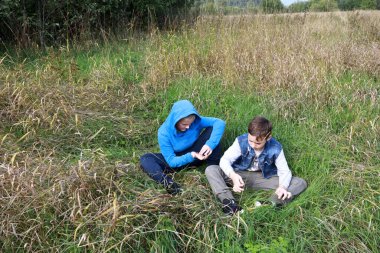 Yazın çimenlerde dinlenen iki çocuk, Karelia.