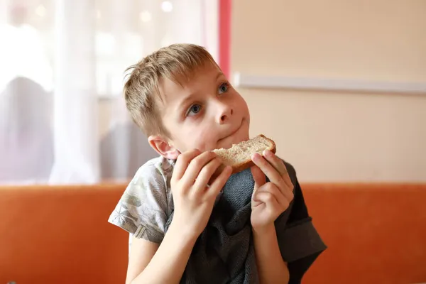 Criança Faminta Comendo Pão Restaurante — Fotografia de Stock