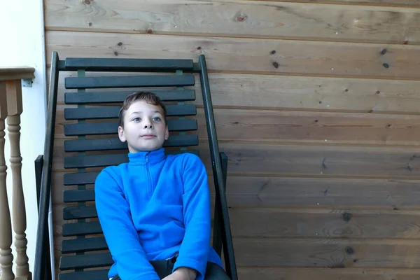 儿童坐在室外木制椅子上的画像 — 图库照片