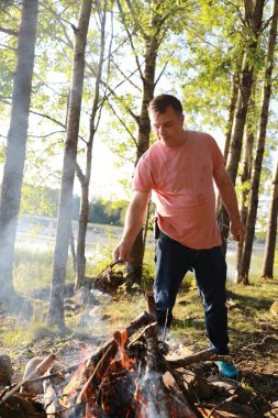 Yazın ormanda şenlik ateşi yakan adam, Karelia.