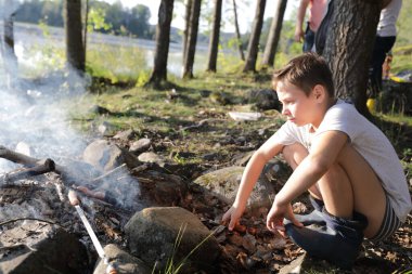Ormanda sosis kızartan çocuk, Karelia.