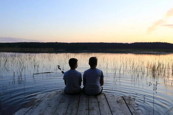 Niños Sentados Puente Madera Junto Lago Atardecer Karelia —  Fotos de Stock