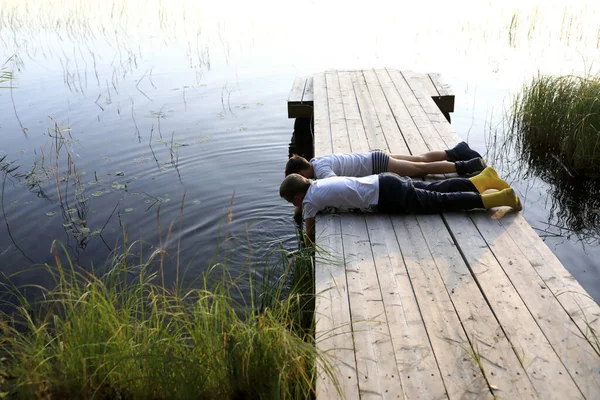 Dwoje Dzieci Bawiących Się Latem Drewnianym Moście Nad Jeziorem Karelia — Zdjęcie stockowe