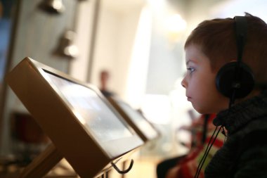 Kulaklıkla müzik dinleyen bir çocuğun portresi