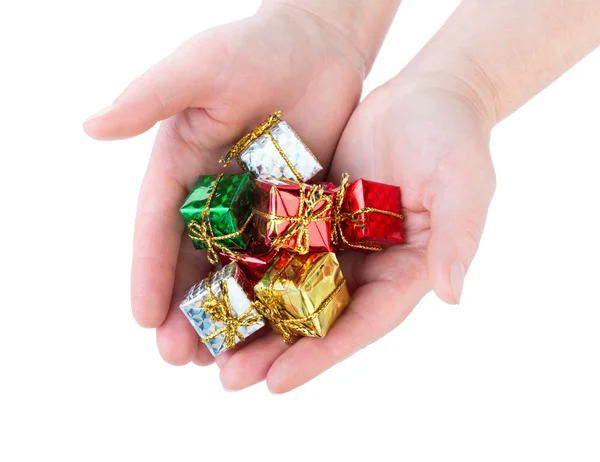 Mujer sostiene muchos hermosos pequeños regalos de Navidad en el respaldo blanco — Foto de Stock