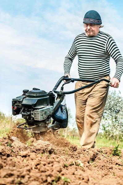 Un fermier labourant le champ. Cultiver le tracteur sur le terrain — Photo