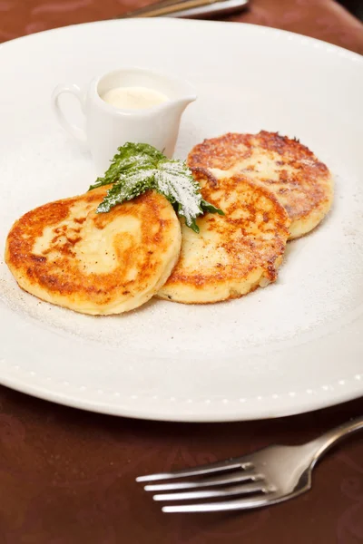 Cheese pancakes with sour cream — Stock Photo, Image