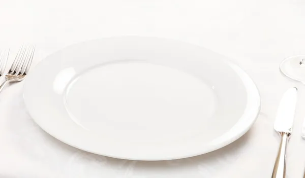 Bílý prázdný talíř s vidličkou a nožem — Stock fotografie