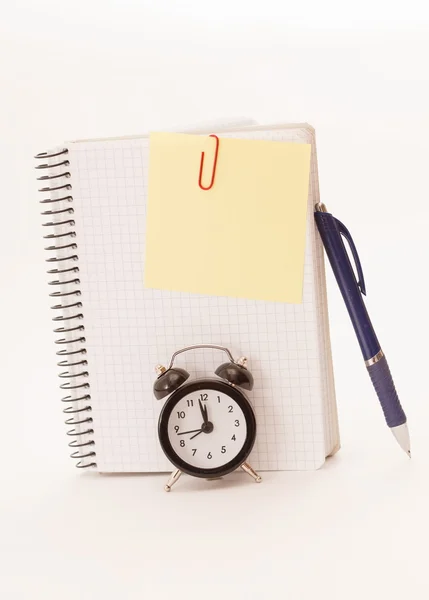 Relógio despertador, folha de caderno em branco no branco — Fotografia de Stock