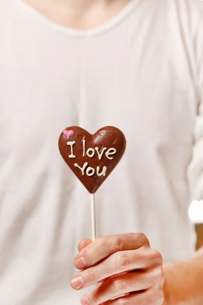 Homem com coração de chocolate nas mãos — Fotografia de Stock