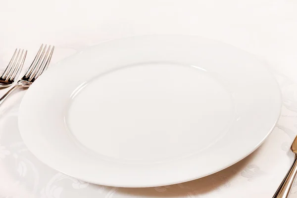 Biały pusty talerz z widelcem i nożem — Zdjęcie stockowe