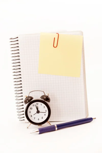 Relógio despertador, folha de caderno em branco no branco — Fotografia de Stock
