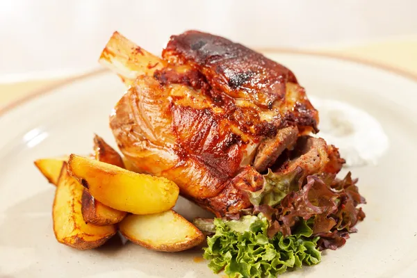 Roasted pork knuckle with potatoes — Stock Photo, Image