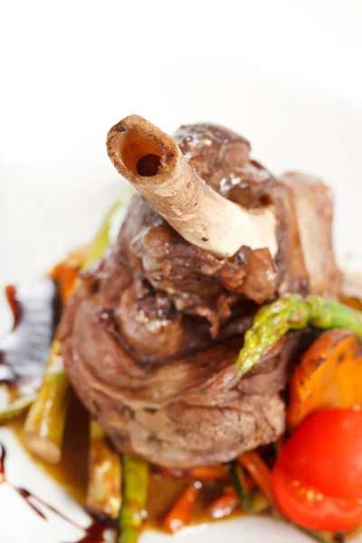 Chuletas de cordero en una cama de verduras — Foto de Stock