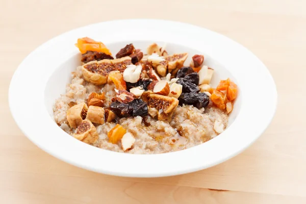 Oatmeal with raisins, nuts and maple syrup — Stock Photo, Image