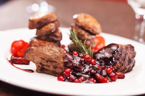 Beef steak with potatoes and cranberry sauce — Stock Photo, Image