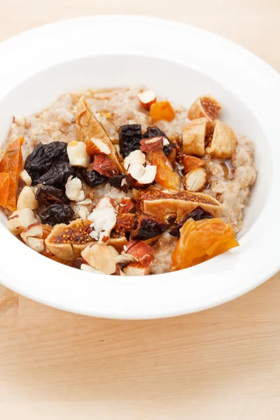 Oatmeal with raisins, nuts and maple syrup — Stock Photo, Image