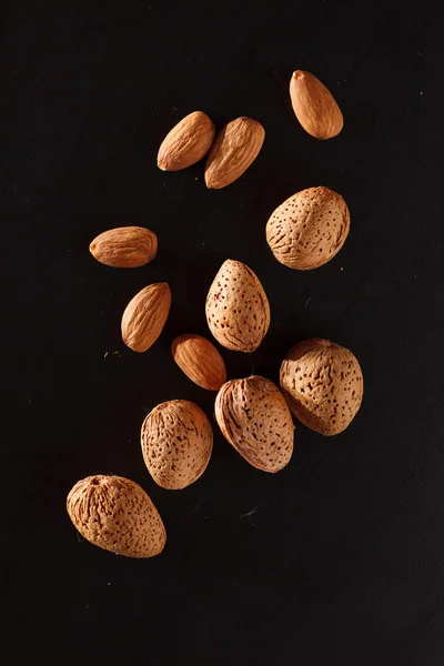 Almond on black background — Stock Photo, Image