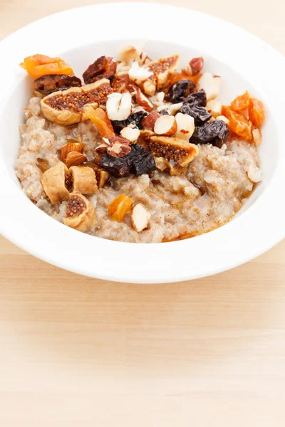 Oatmeal with raisins, nuts and maple syrup — Stock Photo, Image