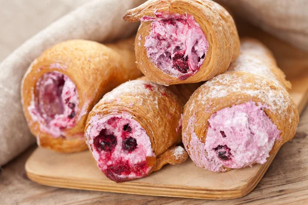 Cream-filled pastry roll on the wood board — Stock Photo, Image