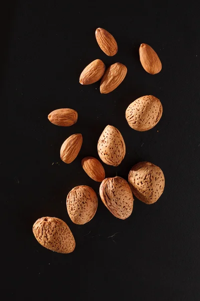 Almond on black background — Stock Photo, Image