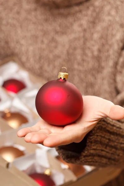 Bola de Natal nas mãos — Fotografia de Stock