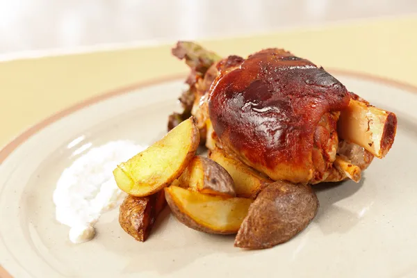 Roasted pork knuckle with potatoes — Stock Photo, Image