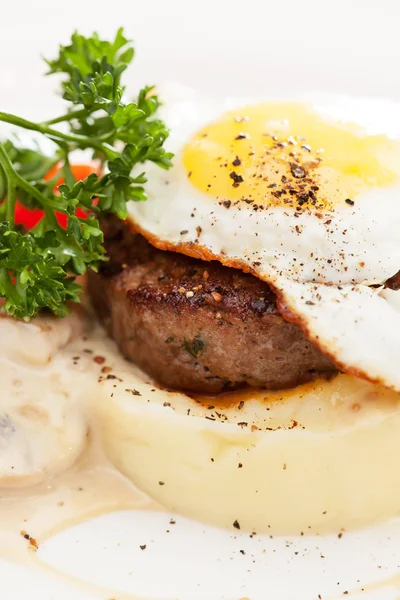 Fried egg with steak and potatoes — Stock Photo, Image