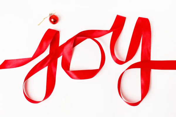 Vreugde woord geschreven in rood lint — Stockfoto