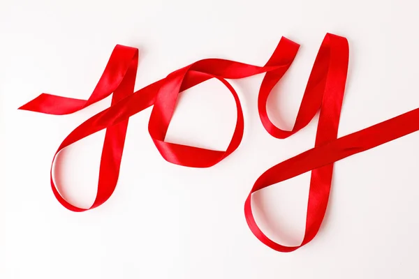 Vreugde woord geschreven in rood lint — Stockfoto