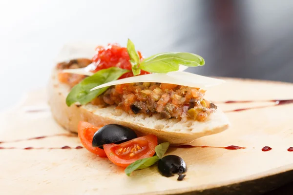 Italian appetizer bruschetta with tomato, basil and black olives — Stock Photo, Image
