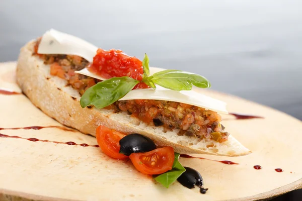 Bruschetta aperitivo italiano com tomate, manjericão e azeitonas pretas — Fotografia de Stock