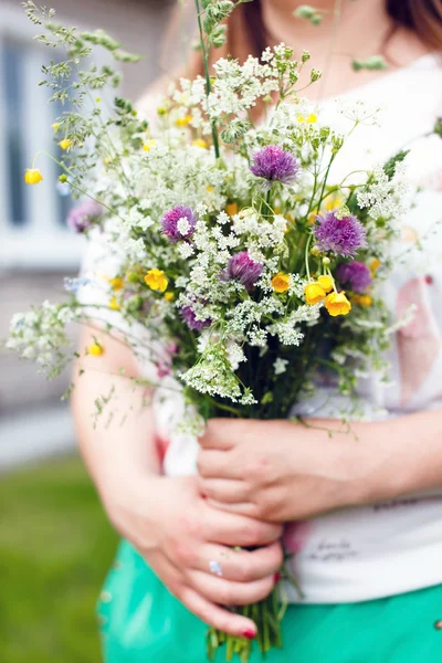 Vrouw bedrijf wilde bloemen — Stockfoto
