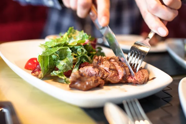 Omul mănâncă carne cu salată — Fotografie, imagine de stoc