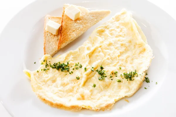 Omelette, vegetables and toasts with butter — Stock Photo, Image
