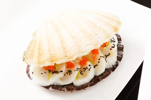 Scallops presented on a scallop shell — Stock Photo, Image