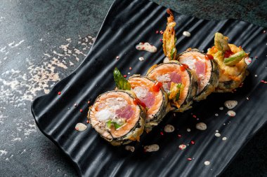 Siyah tabakta tempura sushi.