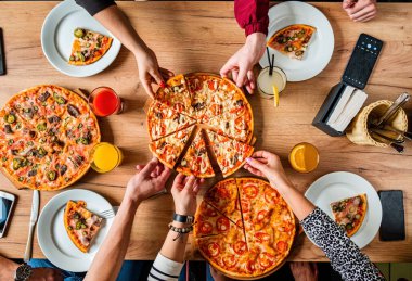 Bir grup insan pizza yemek. 