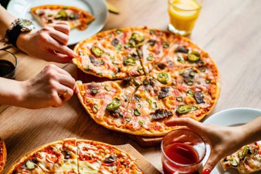 Bir grup insan pizza yemek. 