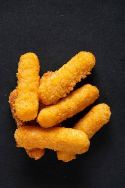 Siyah arkaplanda peynir çubukları