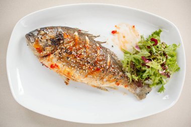 Taze bitki ve limonlu kızarmış balık. 