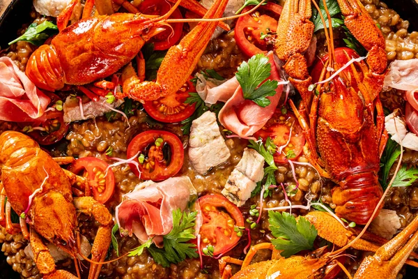 stock image Catalan paella with shrimp and blue fideua on a rustic wooden background.