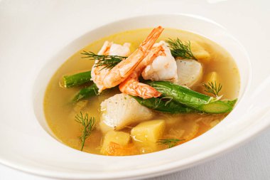 Beyaz arka planda deniz ürünleri çorbası.