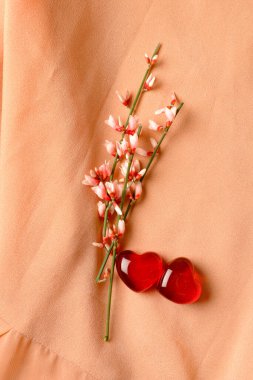 ipek arka planda pembe çiçekler ve kırmızı kalpler