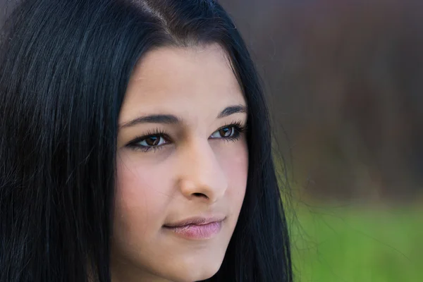 Porträtt på nära håll av unga vackra kvinnan, på grön bakgrund natur. — Stockfoto